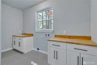 Laundry room is spacious and features butcher block counters and lots of storage,