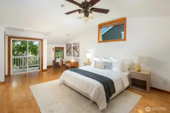 The primary easily holds a king-sized bed and a variety of accessory furnishings.  Vaulted ceilings, fan, hardwood floors and a private balcony.