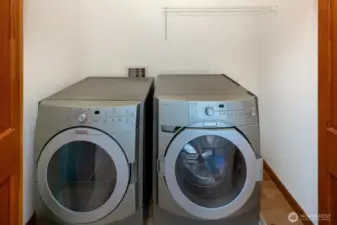 Washer and dryer with shelving are conveniently located behind doors in the primary bedroom