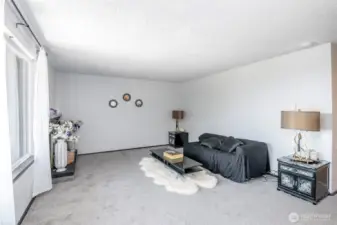 Living room with ample sunlight from the large windows.
