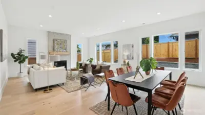 Great Room and Kitchen Connection:  Thoughtfully designed for light, flow, and connection, the main living space blends modern warmth with everyday livability. Wide-plank floors carry throughout, guiding you from the inviting dining area to the sunlit great room anchored by a sleek, tile-wrapped fireplace. Oversized windows bring the outdoors in, enhancing the sense of openness and calm.