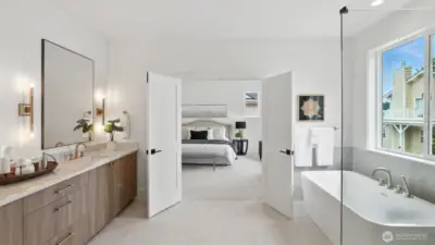 Spa-Inspired Bath: A statement in calm sophistication, the primary bath combines timeless design with modern indulgence. Dual vanities, brass-accent lighting, and a deep soaking tub invite relaxation, while the walk-in glass shower and broad picture window deliver a true spa-day atmosphere at home.