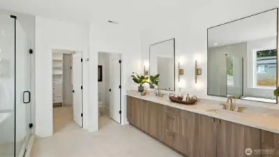 Spa-Inspired Bath:  A statement in calm sophistication, the primary bath combines timeless design with modern indulgence. Dual vanities, brass-accent lighting, and a deep soaking tub invite relaxation, while the walk-in glass shower and broad picture window deliver a true spa-day atmosphere at home.