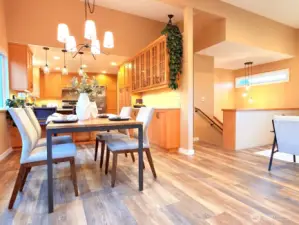 The open living, dining and kitchen features new light fixtures and beautiful flooring throughout (LVP).