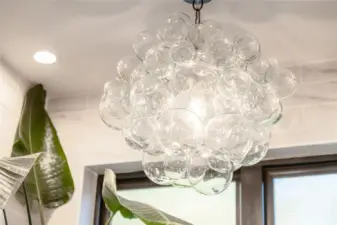 Stunning designer light fixtures like this one in the primary suite leave a lasting impression in virtually every room.