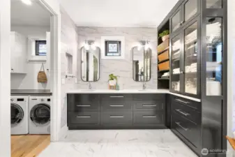 The primary suite walk in closet features Bosch washer and dryer and custom cabinetry.