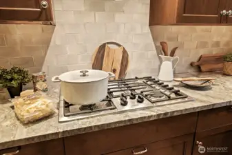 Enjoy cooking in this exceptional culinary space with gas cooking, detailed tile work and cabinets that put everything at your fingertips.