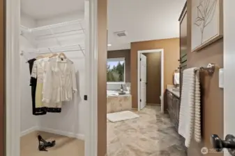 The primary suite offers a spacious walk-in closet and a stunningly updated five-piece bathroom.