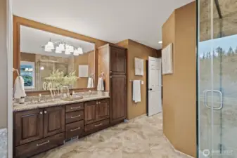 Double vanities and a built-in linen closet provide ample storage in the primary bathroom.