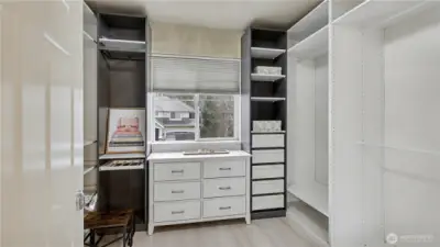 The spacious primary walk-in closet features custom built-ins, drawers, and shelving for effortless organization.