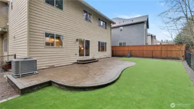 A spacious backyard with a large patio, perfect for outdoor dining, relaxing, or entertaining.