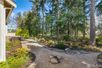 Professionally landscaped yard with granite bubbler fountain creates a serene canvas for your outdoor activities