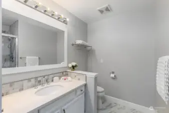The fully-remodeled main floor bath offers quartz countertop, designer mirror and tons of lighting.