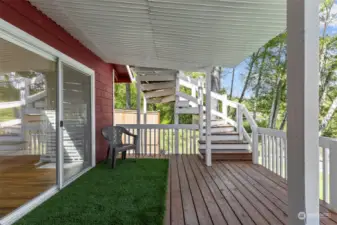 Accessed from the living area, the slider opens onto new covered deck with steps leading to the primary suite above. Enjoy nature's beauty in any weather.