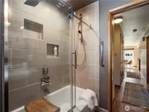 Remodeled shower with tile surround, and original tub.