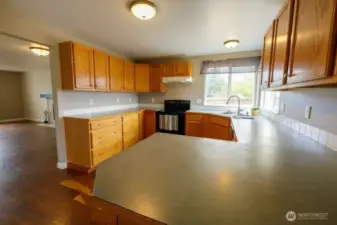 The kitchen provides ample counter space and storage with a corner window above the sink, all appliances included.