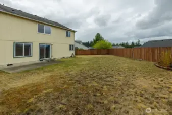 The backyard is a gardener's haven with mature fruit trees, a dedicated garden area, and a spacious shed featuring a potting bench, seed racks, and ample storage