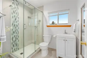 The modern 3/4 bathroom with ceramic tiled shower surround and ceramic tiled flooring.