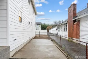 Extensive paved parking pad around home with additional RV/Boat parking on the side of the home.