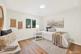 Cozy bedroom with LVP flooring, a sliding window, and a light, neutral finish — versatile enough for a guest room, office, or additional sleeping space.
