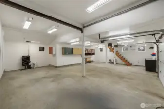 Another view of shop w/ pellet stove and stairs to loft area.