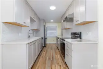 Galley Kitchen  Stainless appliances include glass top 4 burner with stove, range hood, dishwasher, LG Studio French Door smart refrigerator, & combination 'all-in-one unit' microwave/air fryer/toaster oven