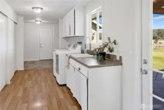 Large mudroom/ laundry room has access to the attached garage and the backyard