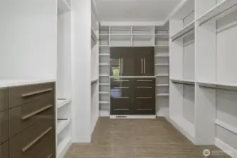 The custom California Closet is a marvel of organization, featuring a personal safe, a convenient pull-out rotating full-length mirror, valet bars, dedicated tie and belt holders, and easily accessible pull-out shelving.