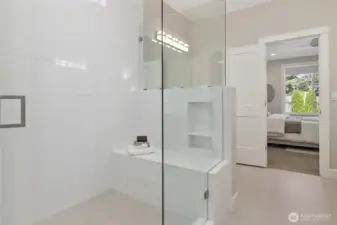 A standout feature of the ensuite bath is the generously sized walk-in shower, complete with comfortable bench seating.