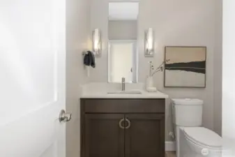 The powder room, just off the grand foyer, is enhanced by beautiful sconce lighting and a surprisingly spacious linen closet. Adding a modern touch throughout, all three bathrooms are equipped with hands-free flush toilets.
