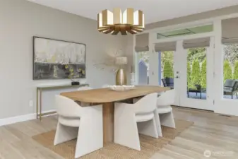 French doors with custom window treatments frame picturesque views of the covered patio and the meticulously landscaped backyard, inviting the outdoors in.