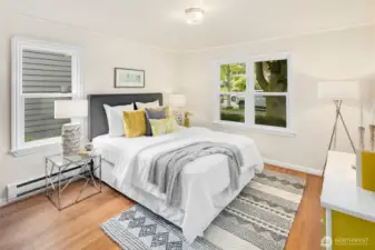 This front, east-facing bedroom, graced as is most of the house, with hardwood floors, is full of charm and leafy street views through the double window.