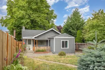 View of the home's exterior from the backyard showcases the charming architecture, mature landscaping, and inviting outdoor spaces.