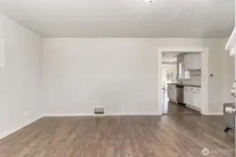 Enter into the spacious living room featuring warm-toned flooring and abundant natural light—perfect for relaxing or entertaining.