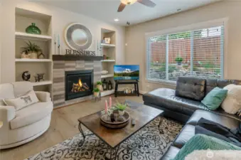 Open Great Room has ceiling fan unique display niches on either side of gas fireplace and is both visually and accoustically coupled to the kitchen and nook areas.