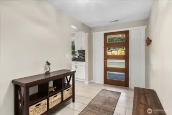 Welcoming entry way with glass-panel front door.