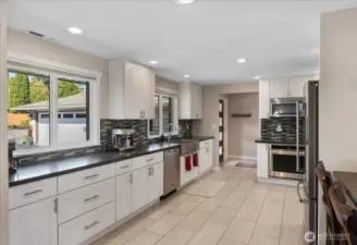Fully remodeled kitchen, designed with quartz counters, soft-close white shaker cabinets, an apron-front stainless sink, and high-end KitchenAid appliances.