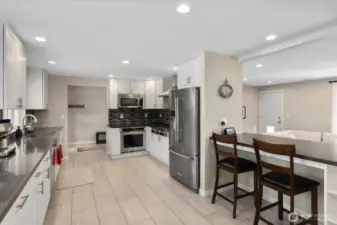 Fully remodeled kitchen, designed with quartz counters, soft-close white shaker cabinets, an apron-front stainless sink, and high-end KitchenAid appliances.  Breakfast bar overlooking the living room.