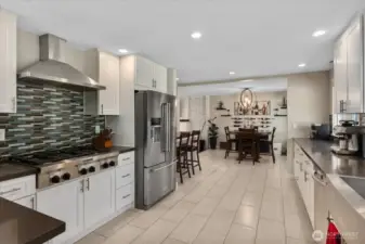 Fully remodeled kitchen, designed with quartz counters, soft-close white shaker cabinets, an apron-front stainless sink, and high-end KitchenAid appliances.  Breakfast bar overlooking the living room.