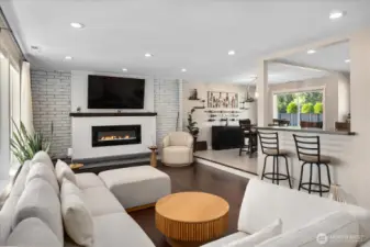 Sunken living room with a Burn Brite fireplace with masonry surround, strand-woven bamboo flooring, and recessed lighting.