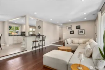 Sunken living room with a Burn Brite fireplace with masonry surround, strand-woven bamboo flooring, and recessed lighting. Open floor plan with breakfast bar.