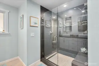 Main bath with a frameless glass shower, quartz counters, double sinks, and new mirrors.