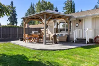 Stamped and stained concrete and a covered back patio with a gas stub for grilling under the large gazebo.