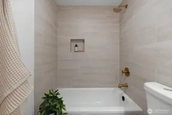 Shared between the second and third bedroom suite's, this newly designed custom tiled bathroom shares this home's theme blending luxury with functionality.