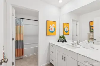 Hall bathroom with quartz top vanity and separate door to toilet and shower for convenience. Actual home is under construction and finishes, colors, and materials may vary. See site agent for details.