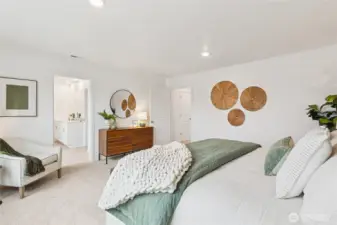 Primary bedroom suite can easily accommodate a King size mattress and more, with the convenience of a connected primary bathroom and walk-in closet. Actual home is under construction and finishes, colors, and materials may vary. See site agent for details.