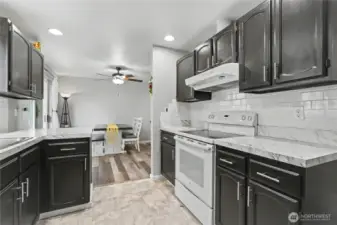 View from your kitchen to your dining room, plenty of cupboards and counter space, included appliances and full-tile backsplash!