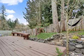 View of your massive deck and back yard, fully-fenced and I love the built-in seating and hammock!