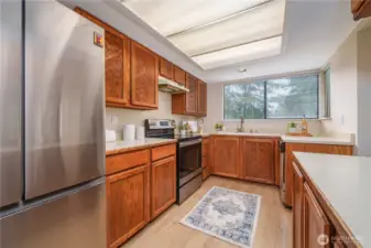 The kitchen features brand-new flooring, a new refrigerator and stove/range, and extensive cabinetry to meet all your storage needs.