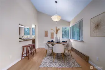 The dining area features a striking wall of windows, vaulted ceilings, and those stunning new floors.